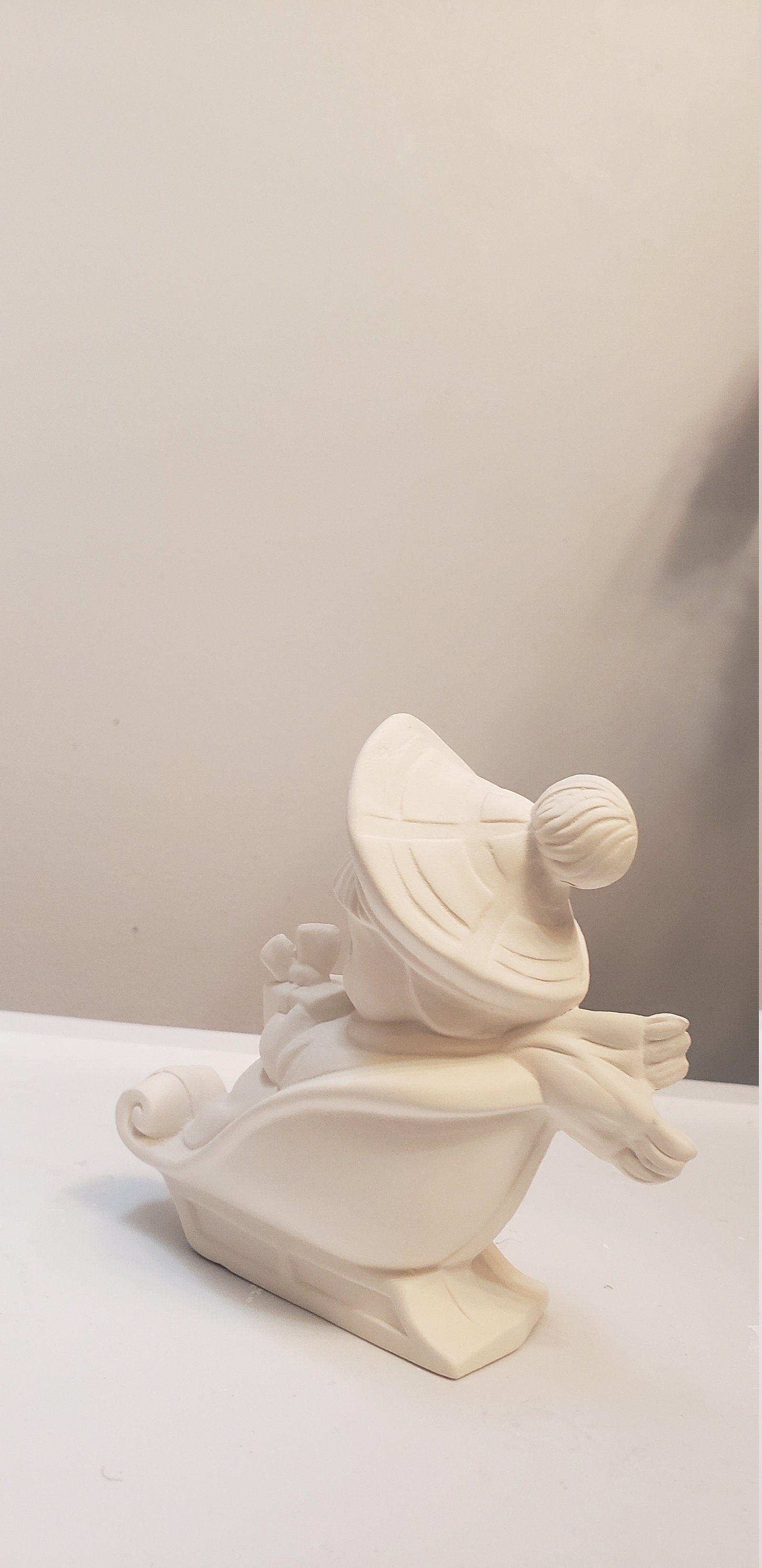 Boy on sled holding gift bisque